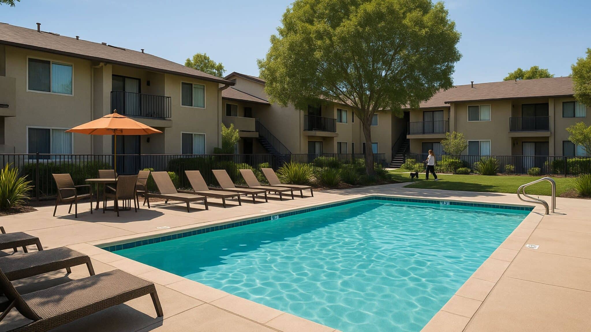 Renovated apartment community in Vista CA with outdoor swimming pool, lounge chairs, and landscaped greenery under sunny skies.