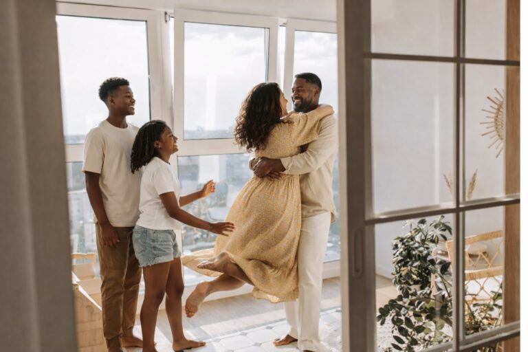 A joyful African American family enjoying natural light in a calm home environment during a home wellness audit