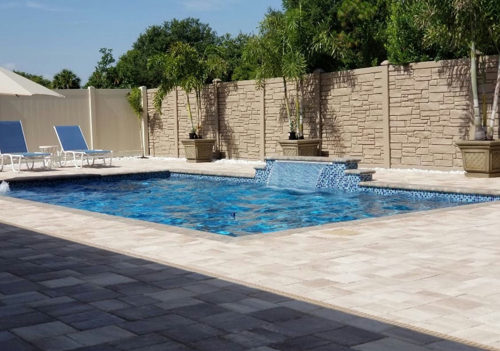 Well-maintained backyard swimming pool with clear water and surrounding patio