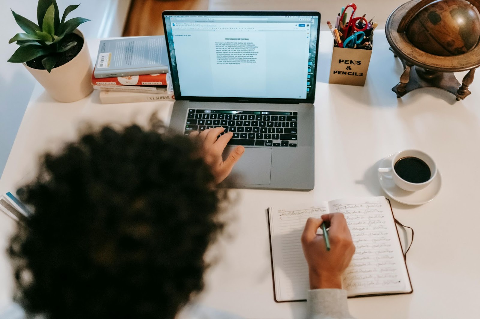 Writer working at a desk with a laptop and handwritten notes during the content creation process