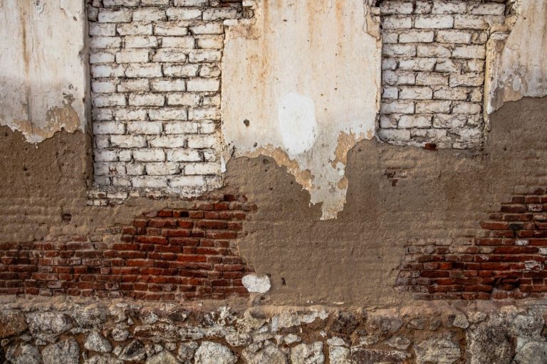 Cracked and deteriorating brick foundation wall showing structural damage