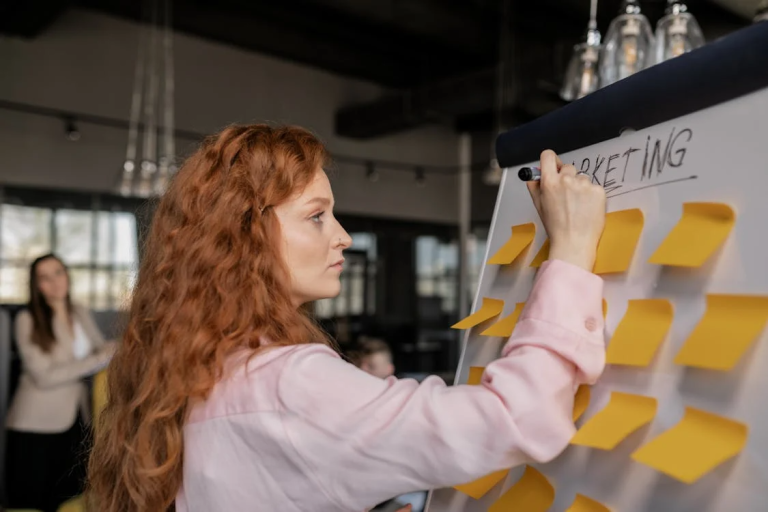 Founder writing a marketing strategy on a board during a business planning session
