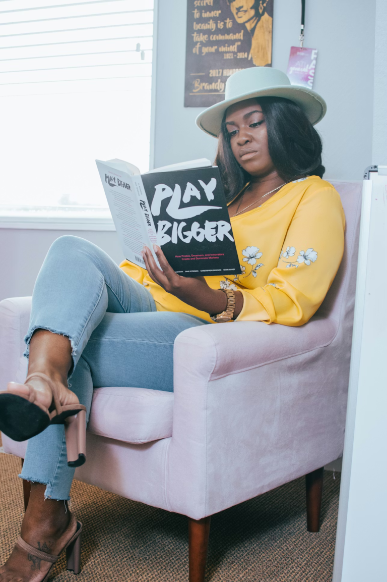 Indie writer sitting in a chair reading a book about growth and strategy