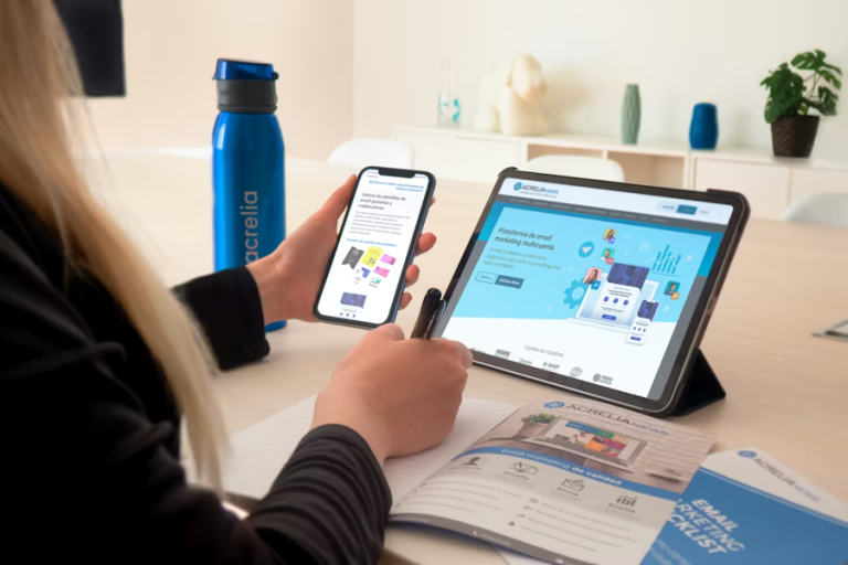 Professional using a smartphone and tablet to manage email and SMS outreach platforms at a desk