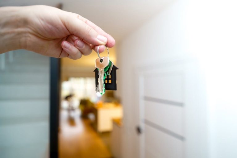 Hand holding house keys representing renting out a room in a private home