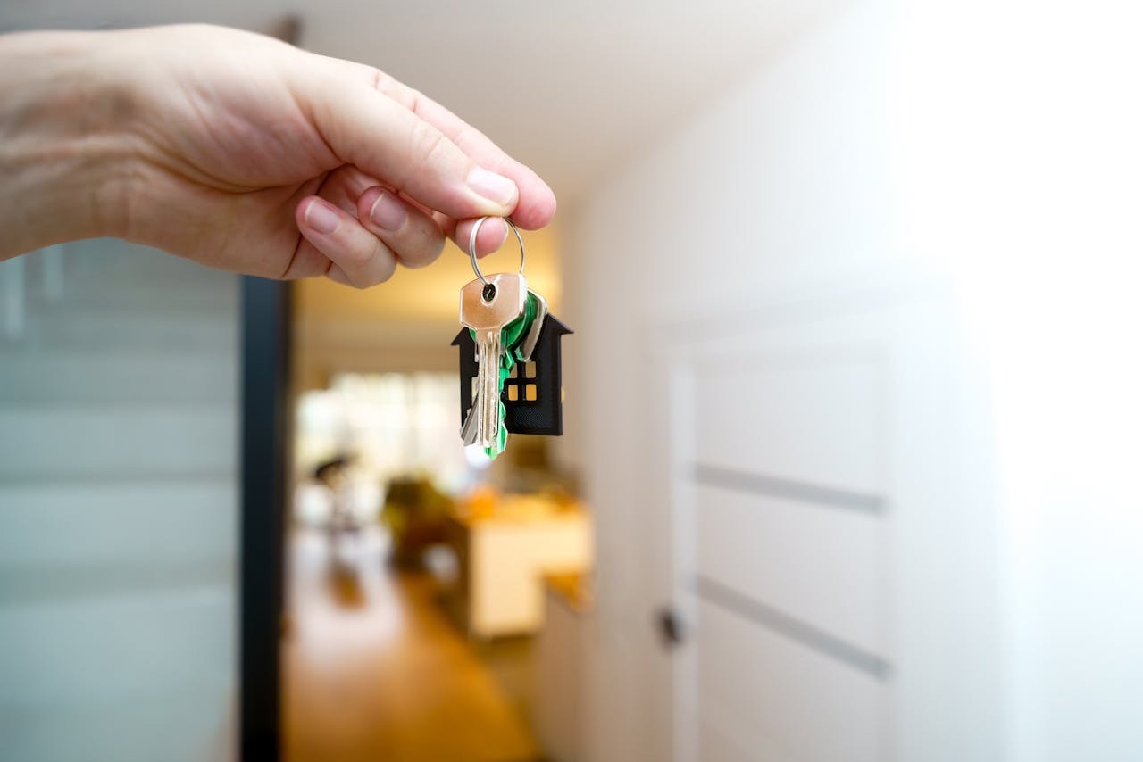 Hand holding house keys representing renting out a room in a private home