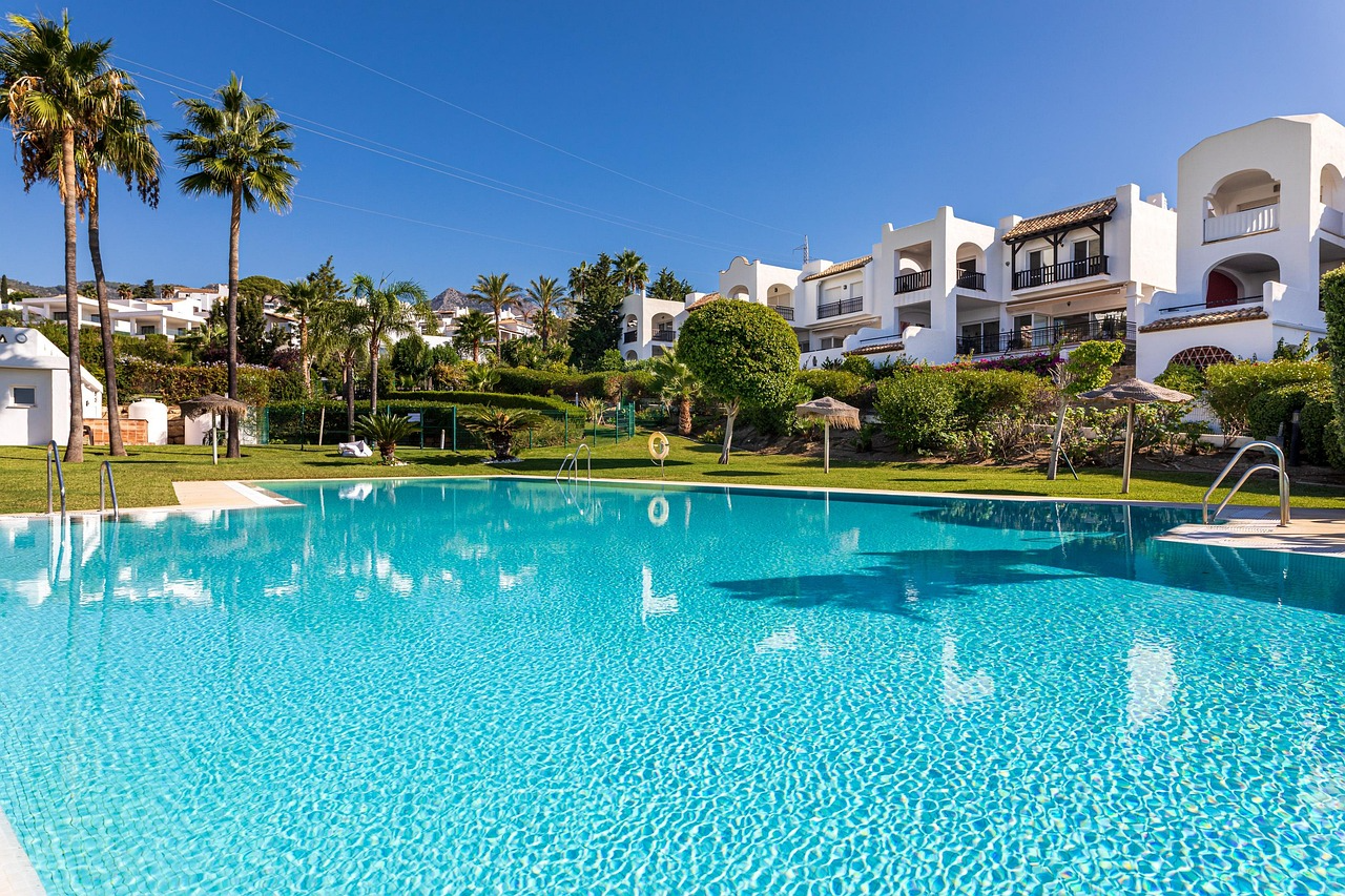 Luxury residential apartment complex with swimming pool and palm trees representing income-generating real estate investments