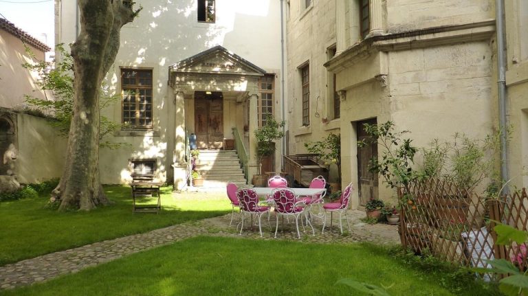 Elegant stone courtyard with outdoor seating and landscaped lawn