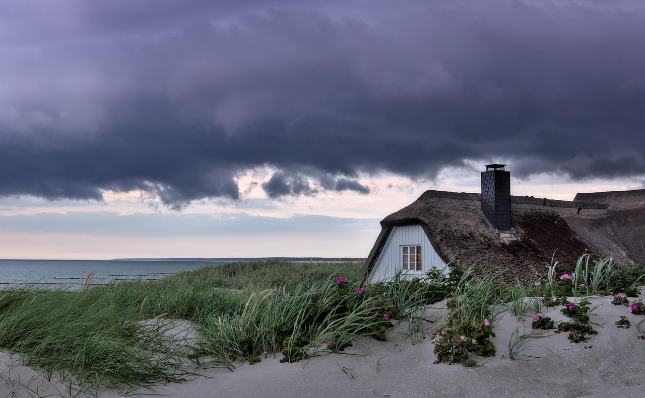Coastal home under dark storm clouds before a storm damage assessment