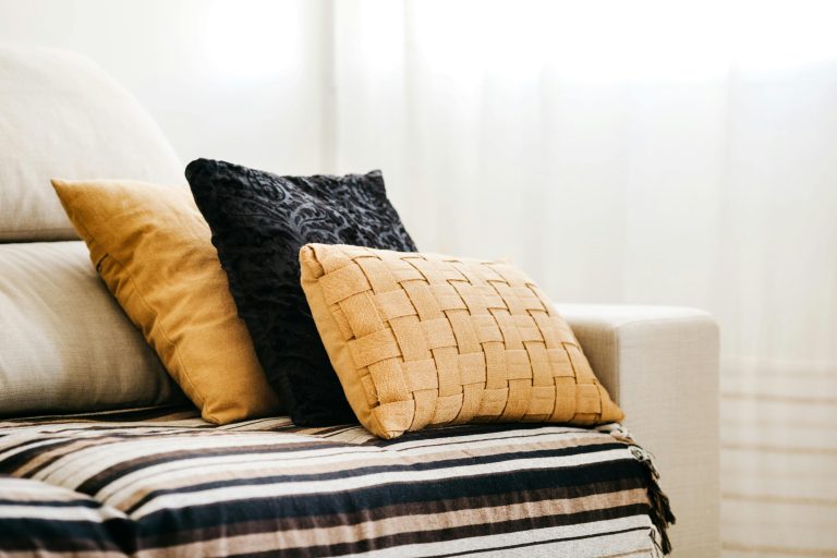 Neutral-toned custom cushions styled on a sofa, showcasing texture, fit, and design quality