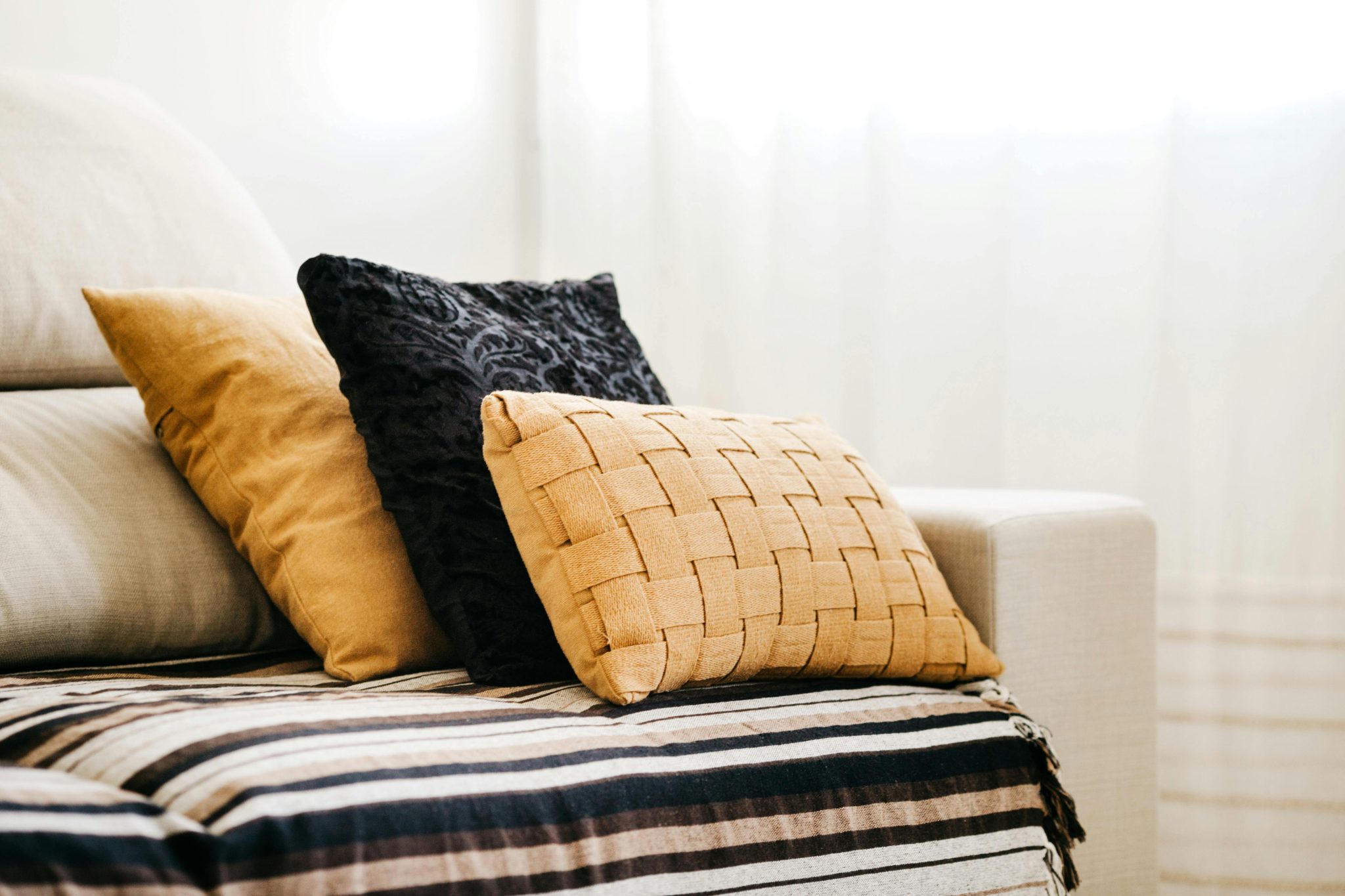Neutral-toned custom cushions styled on a sofa, showcasing texture, fit, and design quality