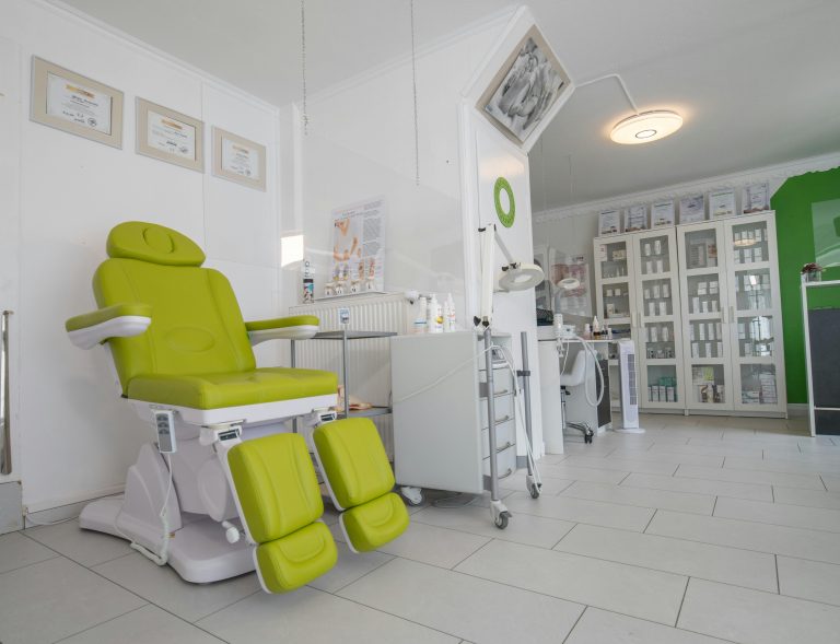 Bright, modern dental clinic interior with a green patient chair and clean treatment area