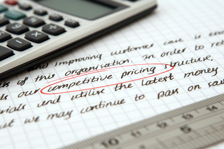 notebook with competitive pricing notes beside calculator for business financial planning