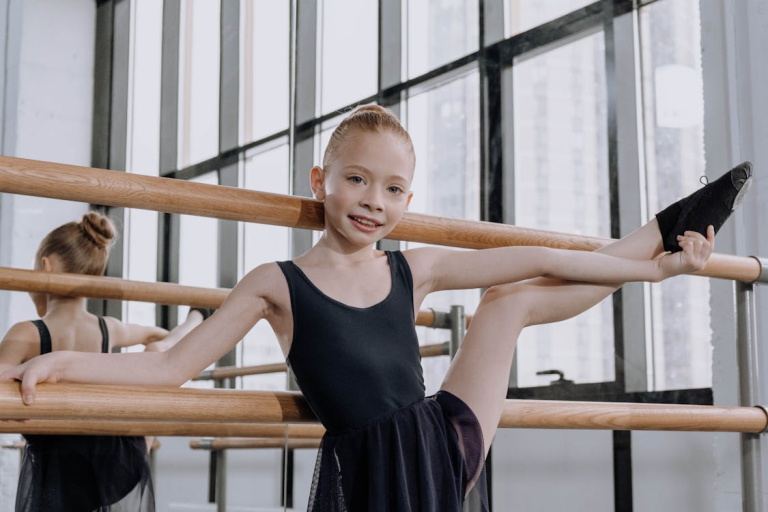 young girl practicing gymnastics at a barre during training