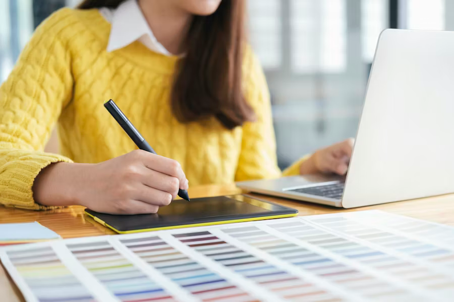 woman using tablet and laptop to manage tasks and stay organized