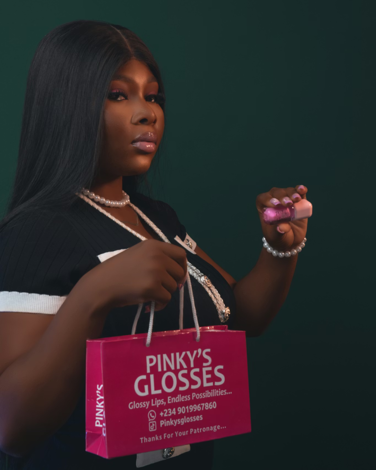 Black woman holding lip gloss product and branded cosmetic packaging