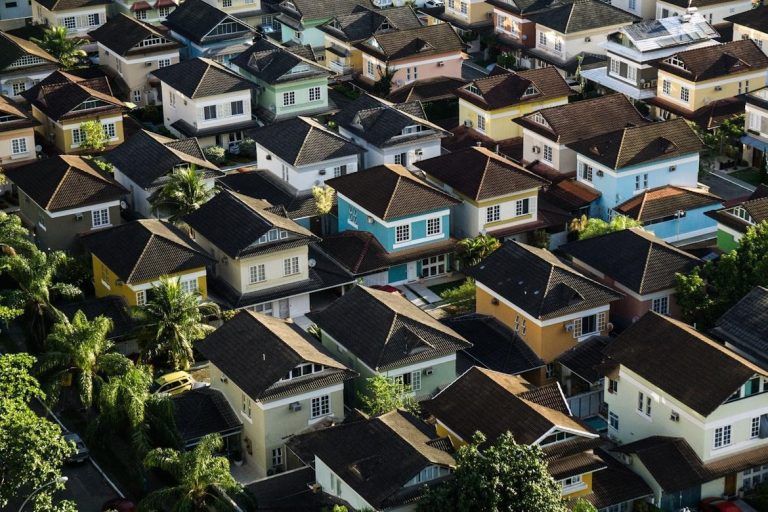 Aerial view of residential homes with different roof types in a neighborhood