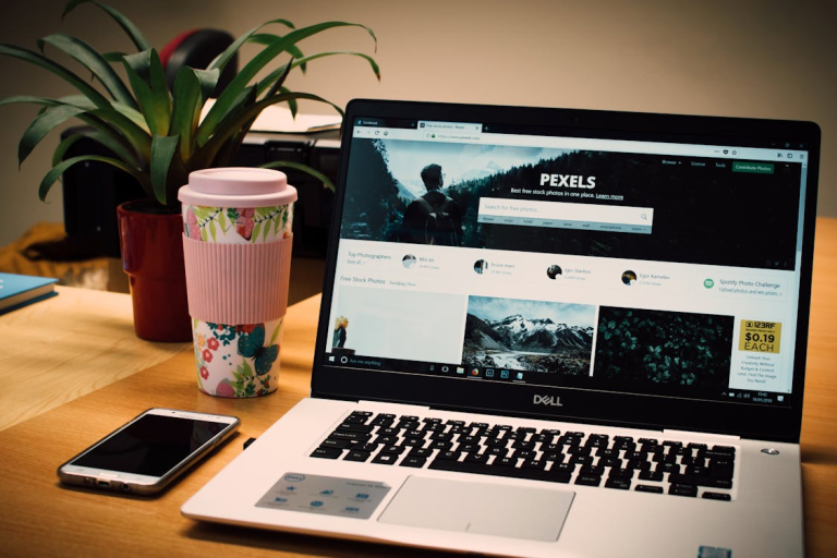 laptop displaying website with coffee and phone on desk for online business visibility