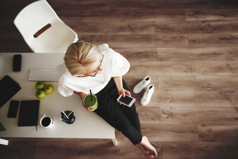 Busy woman taking a wellness break with a healthy drink while working at home