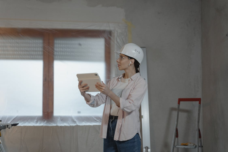 Woman contractor using a tablet while inspecting a home renovation project indoors