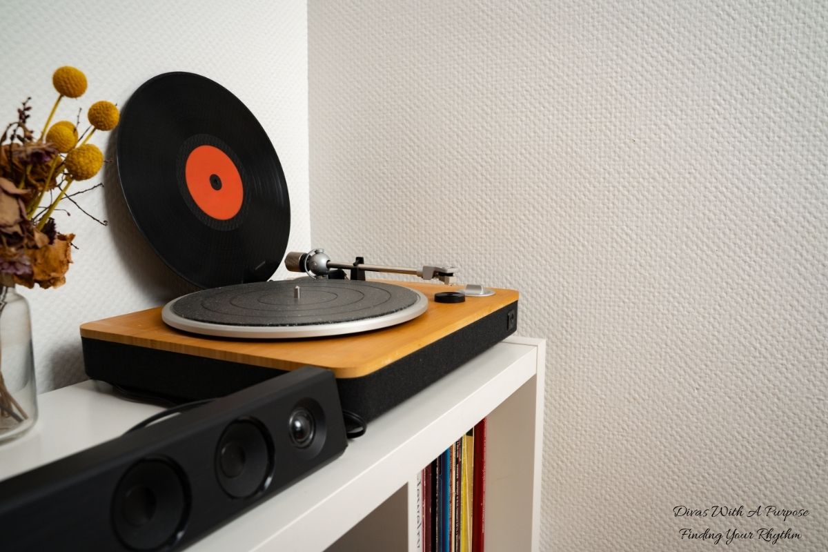 Album vinyl leaning against wall next to vinyl player