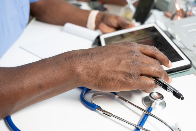 healthcare professional using tablet with stethoscope and digital clinic software