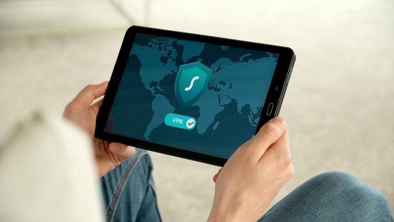 person holding tablet displaying VPN connection with world map and security shield icon