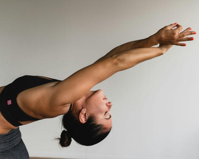 woman practicing pilates stretch exercise as part of beginner instructor training