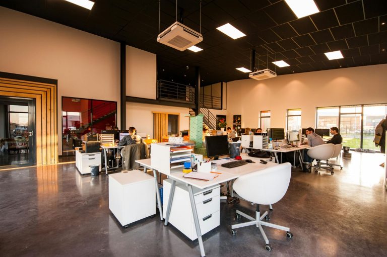 Open office workspace with desks and computers showing ways businesses can reduce premises costs.