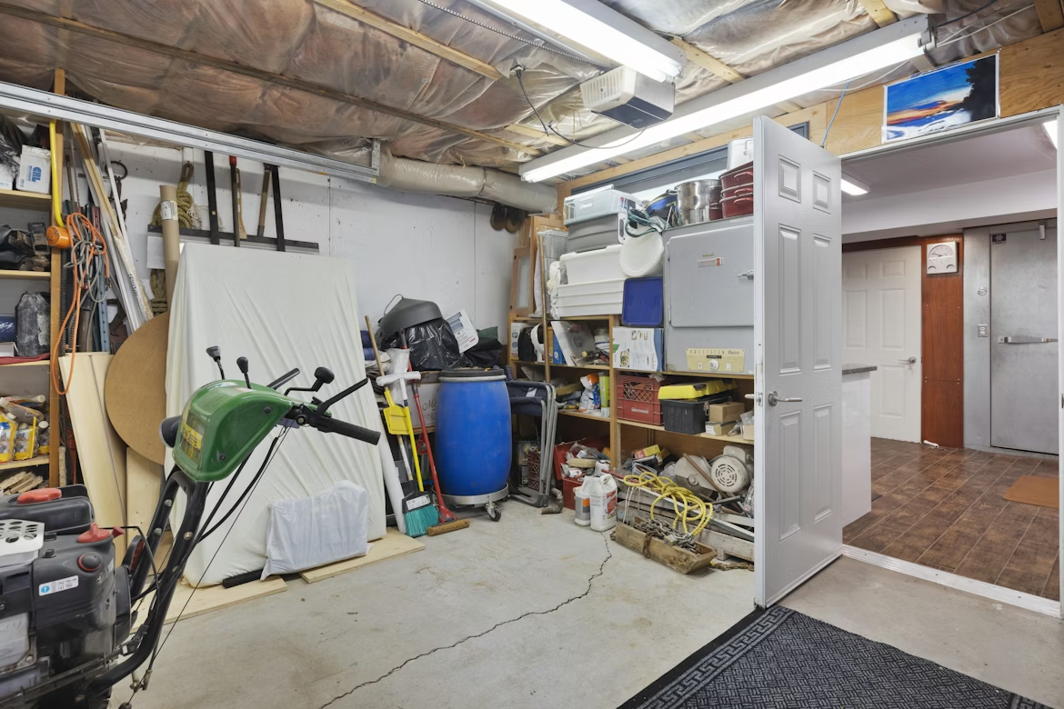 Cluttered garage filled with tools, storage bins, and household items needing organization.