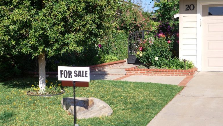 Residential home with a for sale sign in the front yard representing first property investment opportunities