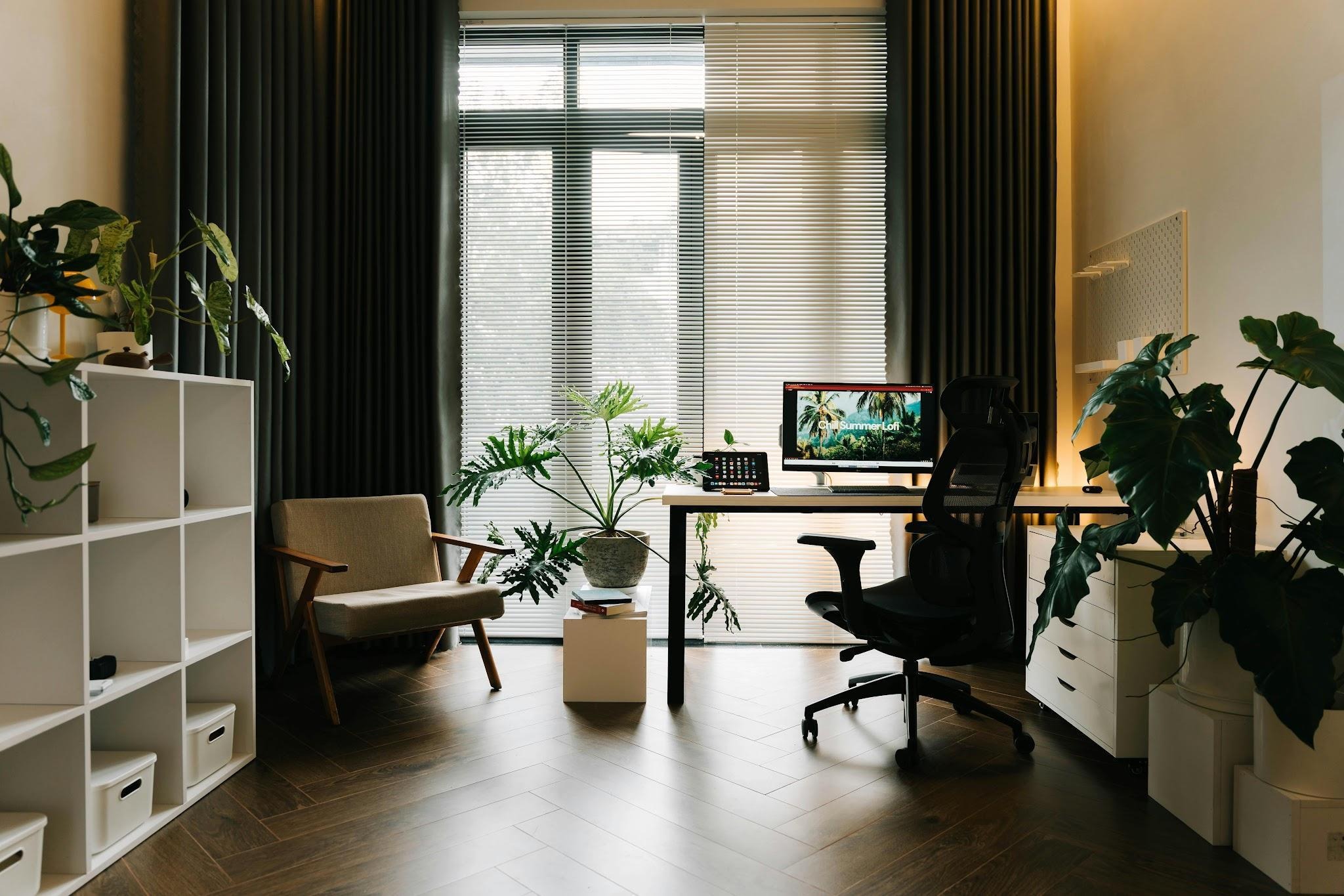 Modern home office with natural lighting, ergonomic chair, desk setup, and indoor plants