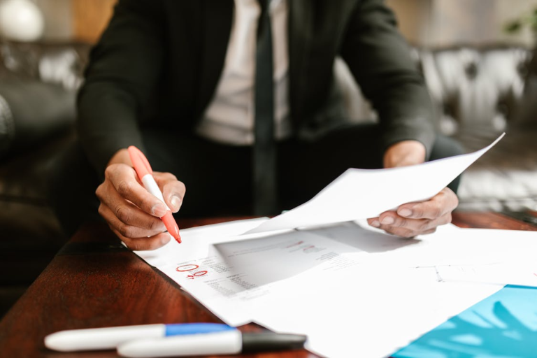 Business professional reviewing paperwork and financial documents for compliance and registration requirements