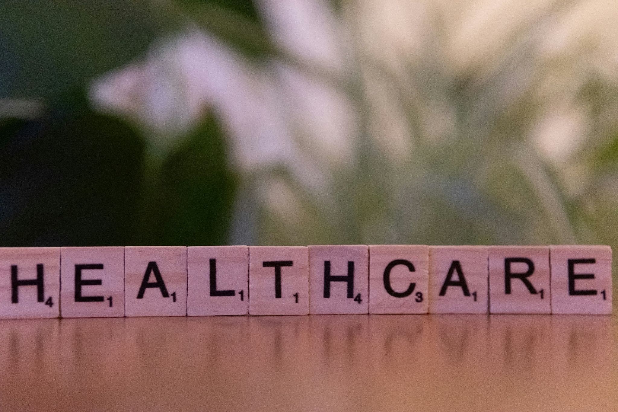 wooden letter tiles spelling healthcare on table representing business growth