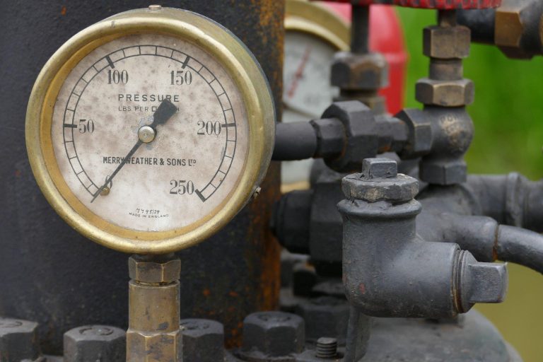 Close-up of a gas pressure gauge connected to industrial gas pipeline equipment