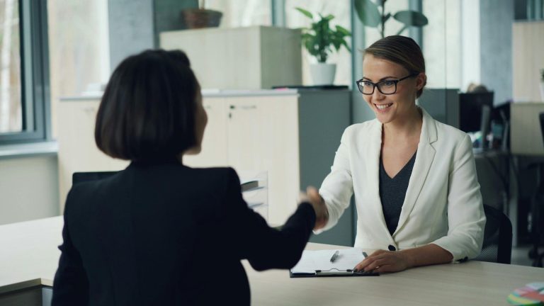 Business professionals shaking hands during a successful corporate client meeting.