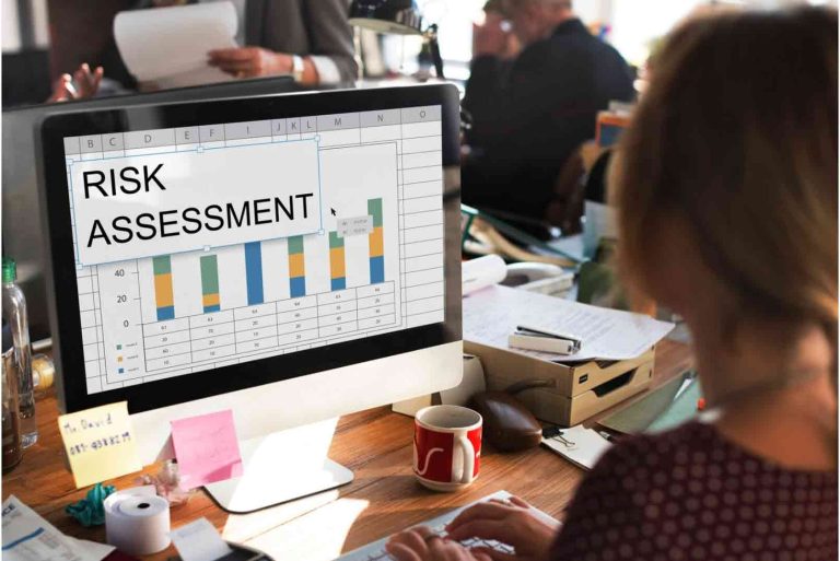 Business professional reviewing risk assessment data and workflow performance metrics on a computer screen