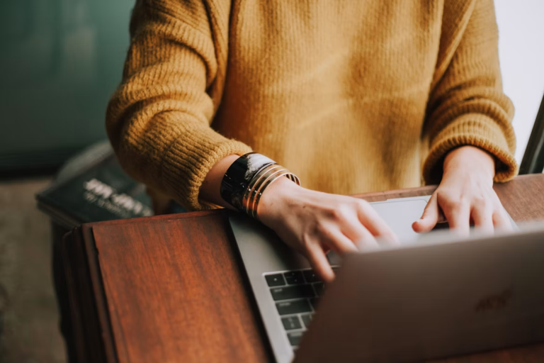 Small business owner working on a laptop while managing daily business operations and finances