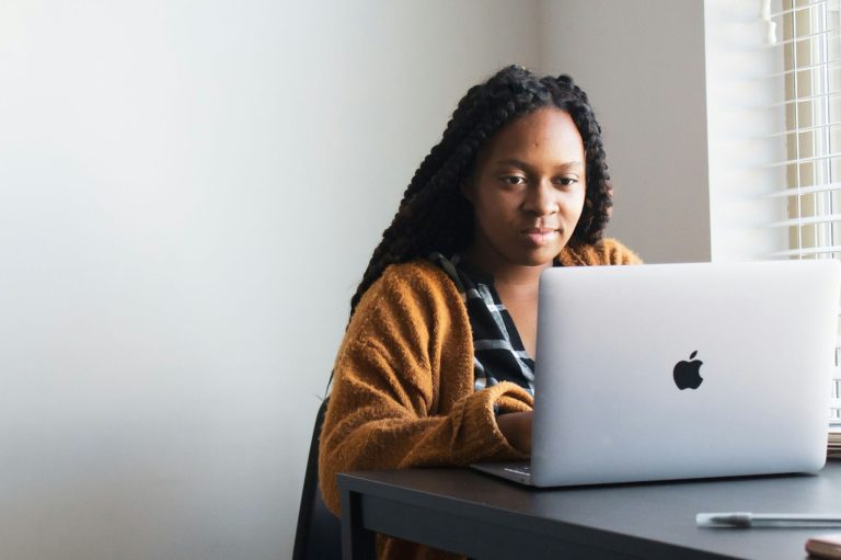 Black woman entrepreneur working on her laptop while building and growing her business