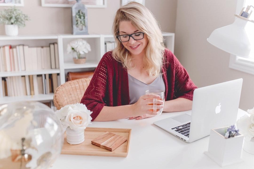Woman entrepreneur reviewing product labels at a desk with a laptop