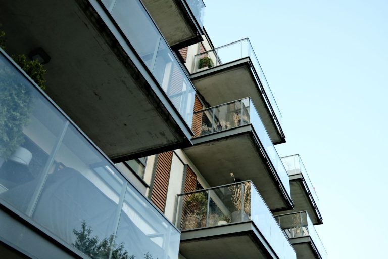 Modern apartment building with multiple balconies representing rental properties managed by a property management company