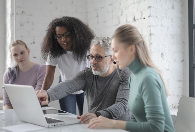 A diverse team of employees collaborating with a manager during a workplace meeting to build a positive workplace culture