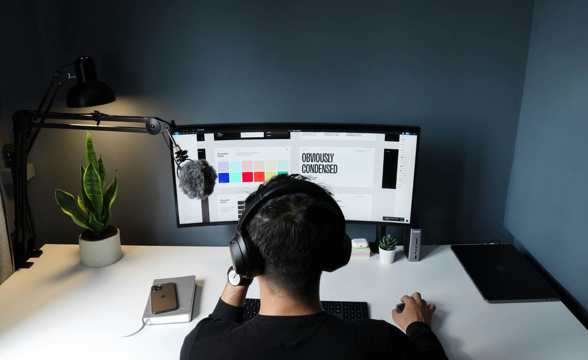 Designer creating digital branding assets for a healthcare technology company on a multi-monitor workstation