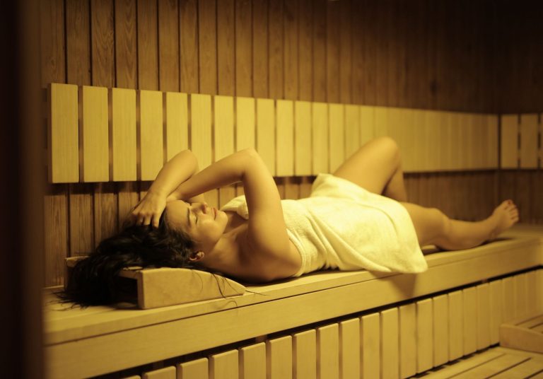 woman lying on sauna bench
