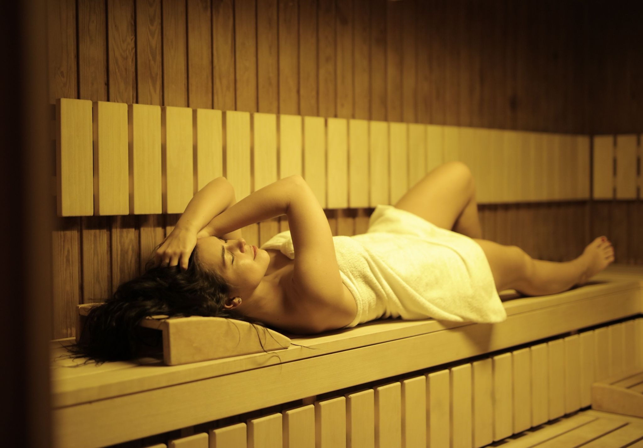 woman lying on sauna bench