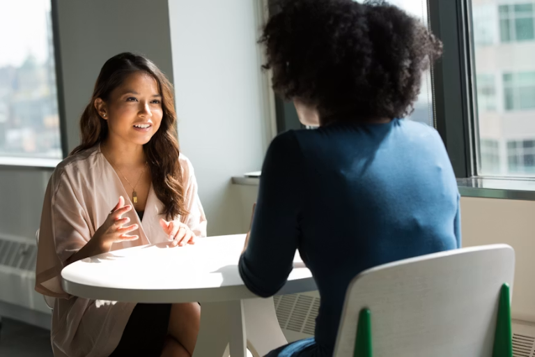 Two professionals engaged in a focused workplace conversation during a one-on-one meeting