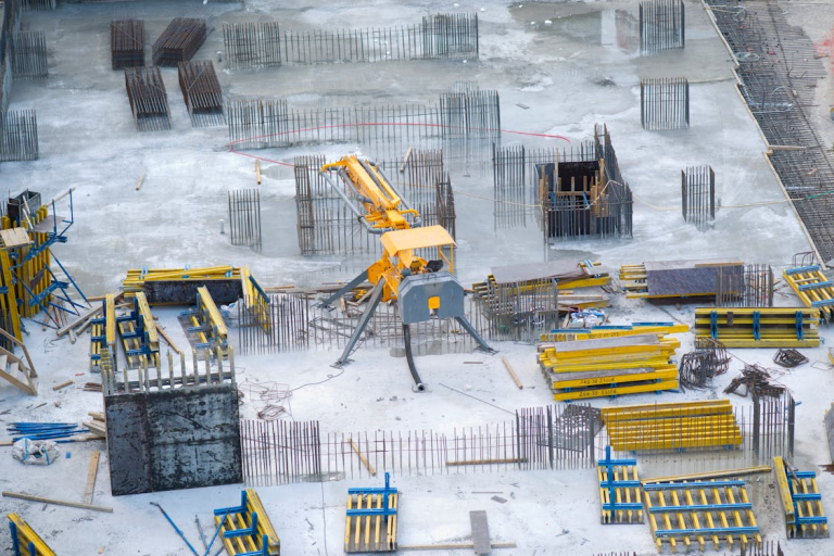Active construction site with equipment, materials, and project infrastructure in place