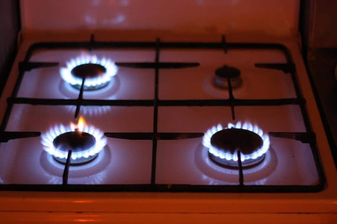 Blue flames burning on a natural gas stove inside a home kitchen