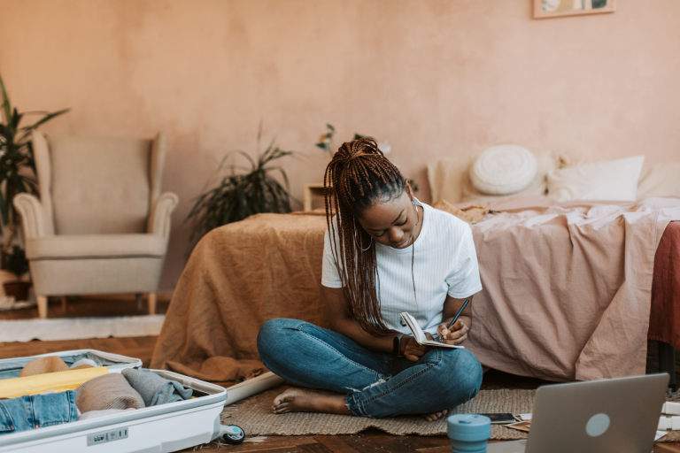 Woman planning an intentional travel itinerary while packing for a meaningful trip