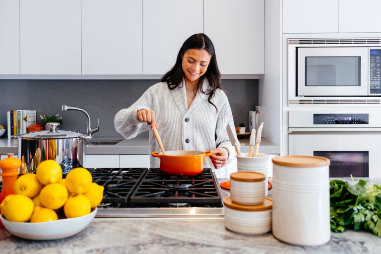 Woman preparing a healthy meal in a bright kitchen to support natural hormone balance and overall wellness.